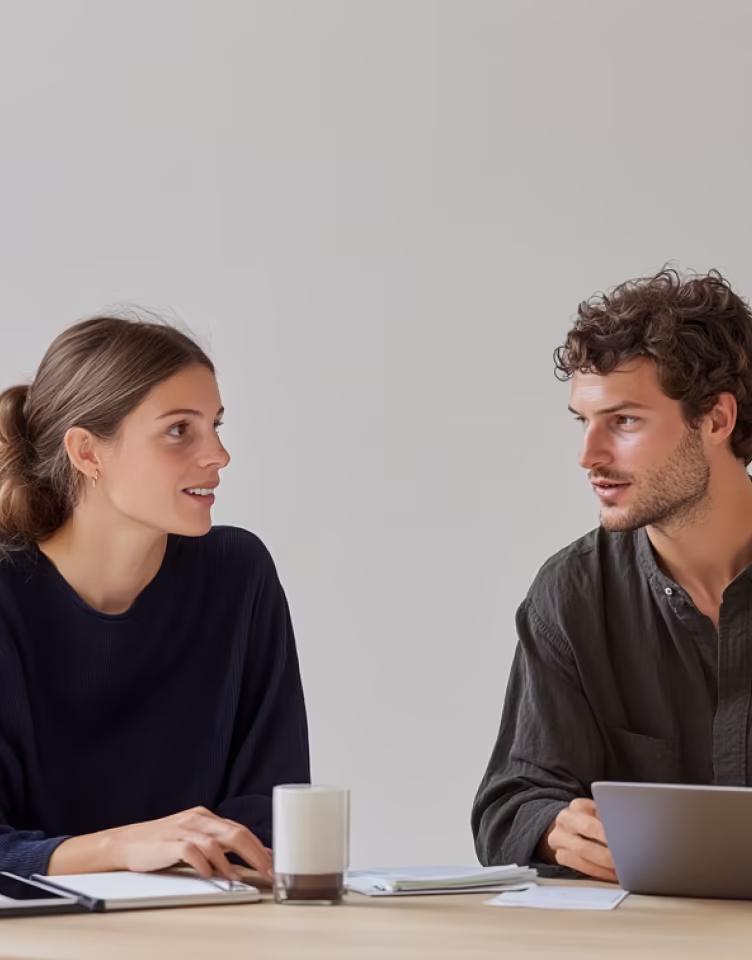Two team members meeting at a desk